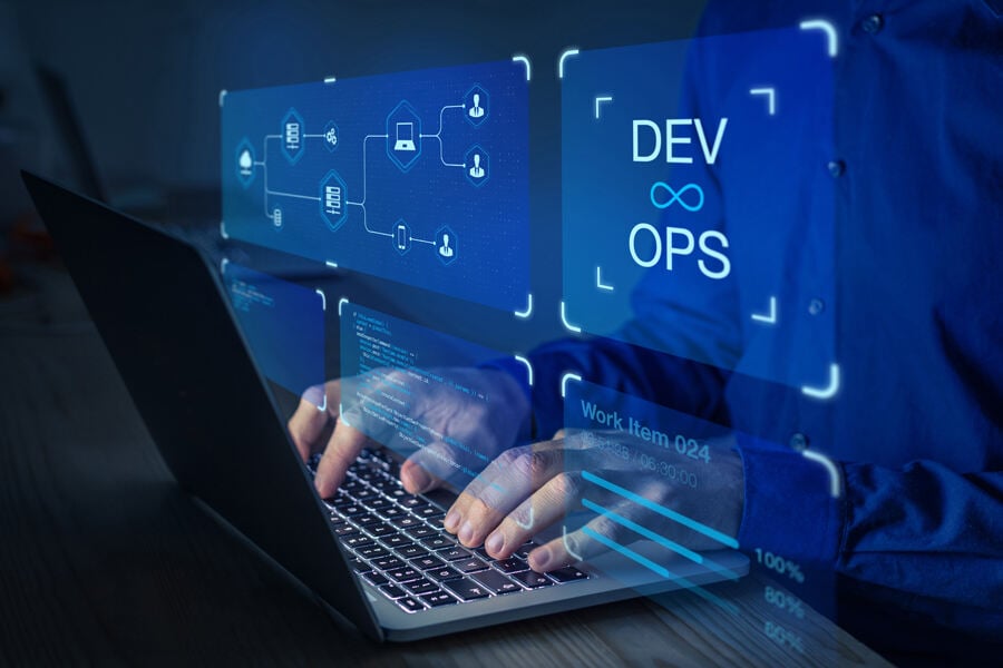 Laptop mit Händen drauf und Grafik im Vordergrund mit der Aufschrift DevOps