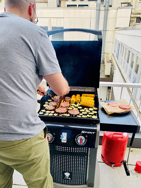 Mann am Grill auf der Brickmakers Dachterasse