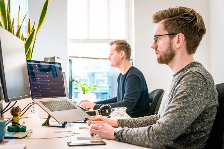 zwei Männer arbeiten am Computer in einem Büro